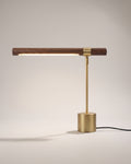Askel desk lamp in brass, slim horizontal arm on a cylindrical base
