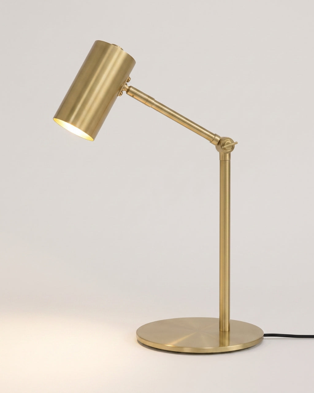 Warno desk lamp in gold, angled shade on a slender adjustable arm