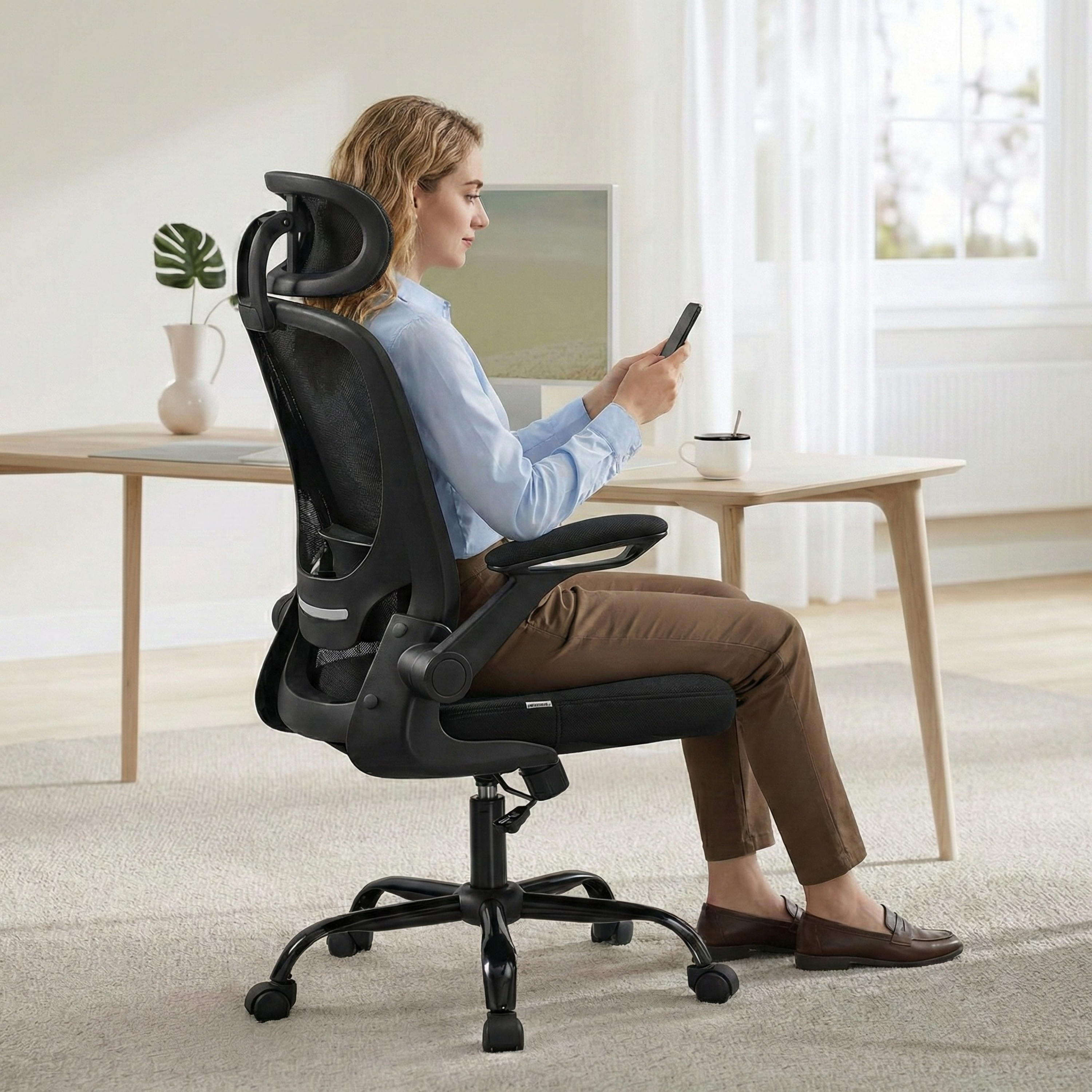 a woman sitting on a black Deskon ergonomic chair with a headrest
