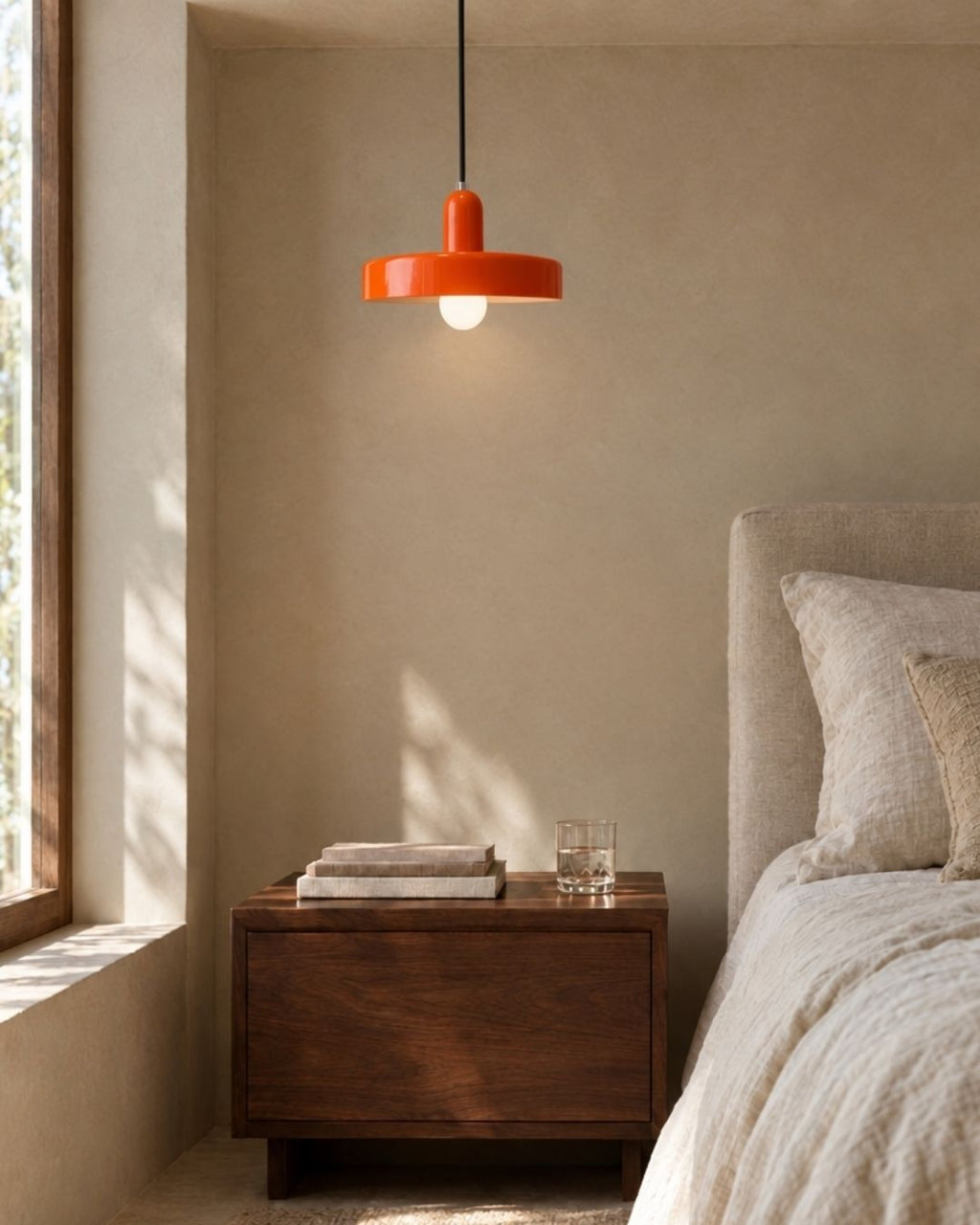 Nyla pendant light in orange, close view above a bed in a bedroom