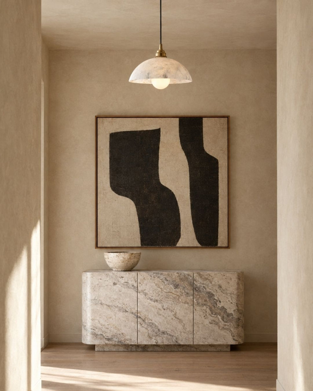 Solvi pendant light in marble and gold, in a beige hallway with artwork
