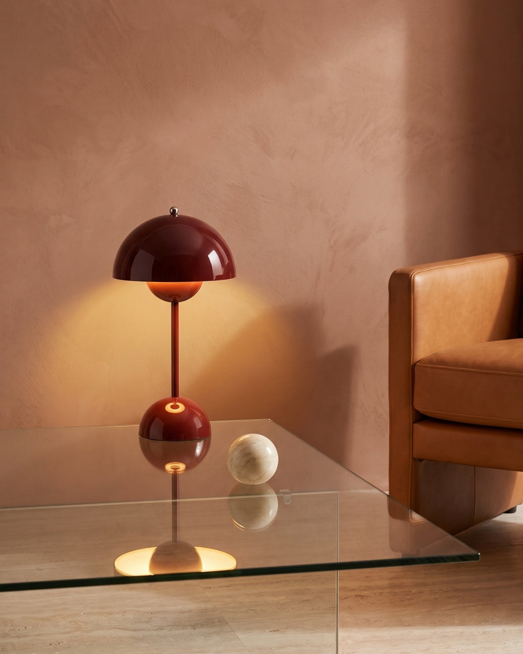 Elsin table lamp in red lit on a glass coffee table