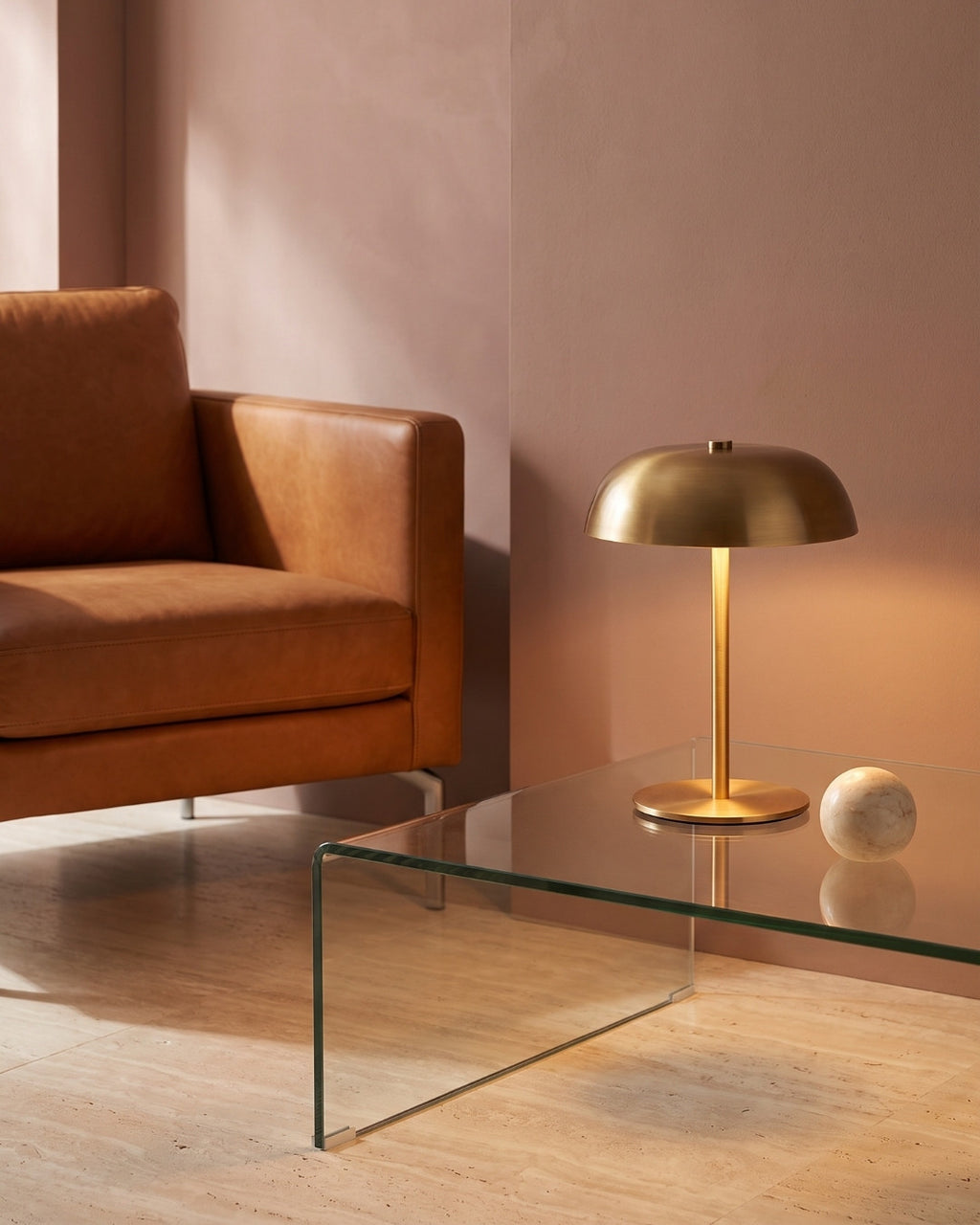 Gavetti table lamp in gold lit on a glass coffee table
