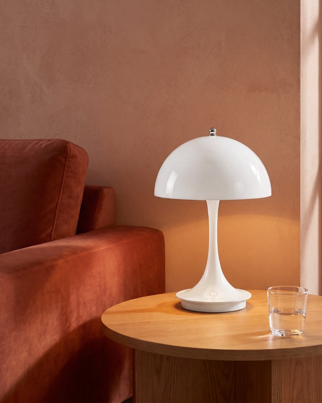 Harvo table lamp in white lit on a side table beside a sofa