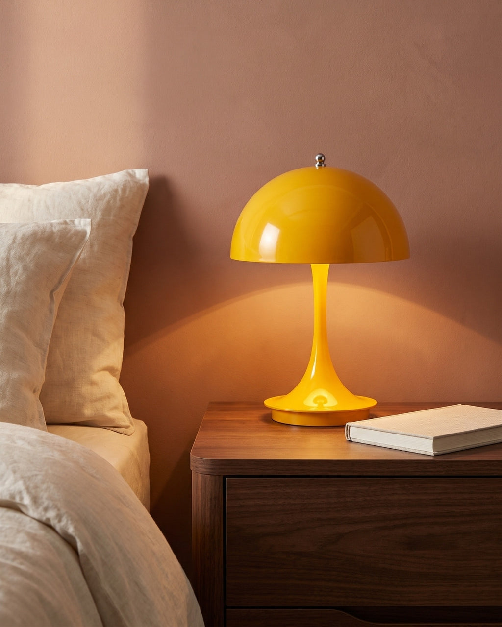 Harvo table lamp in yellow lit on a nightstand in a bedroom