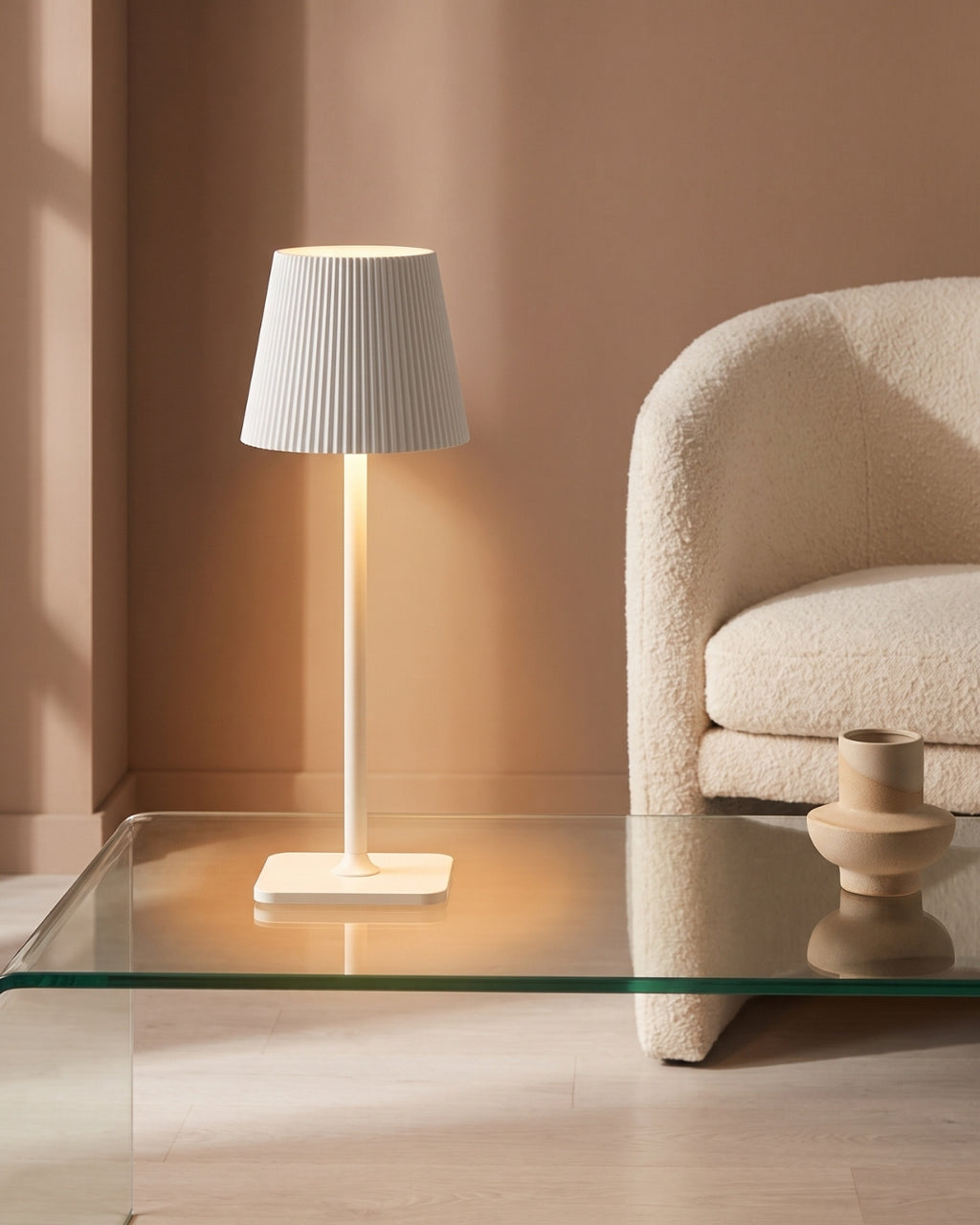 Velmo table lamp in white lit on a glass coffee table